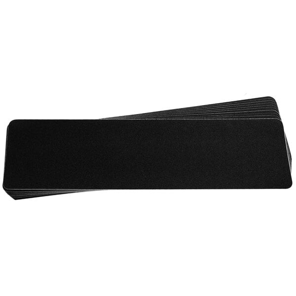 A stack of black rectangular SlipDoctors non-slip stair tread adhesive strips.