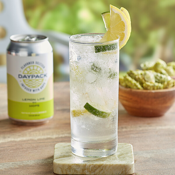 A glass of DayPack sparkling hop water with lemon slices and lime on ice and a can of DayPack lemon lime sparkling hop water.