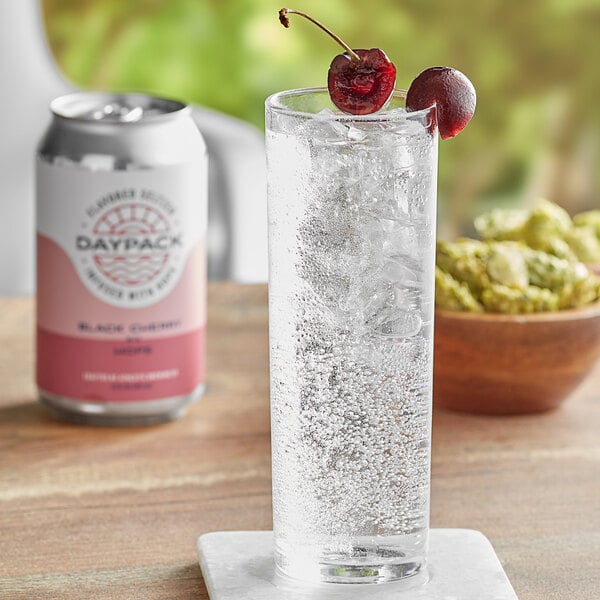 A glass of DayPack Black Cherry sparkling hop water with cherries on top.