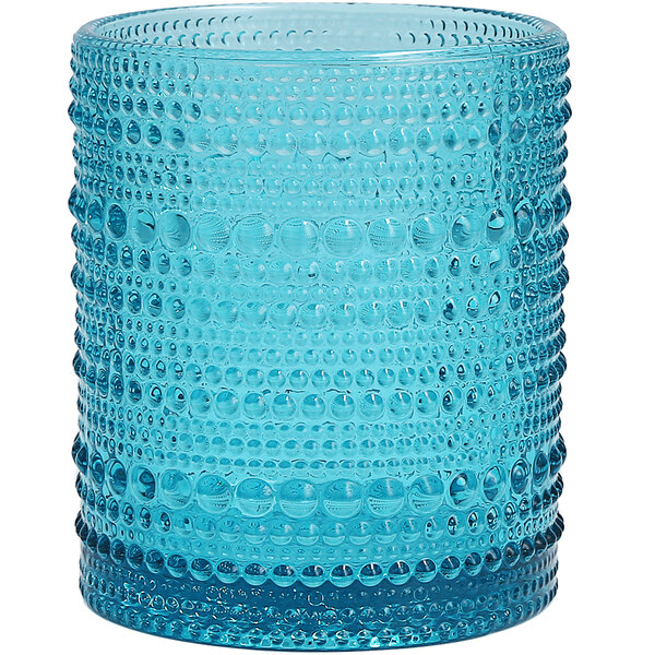 A Fortessa lagoon blue glass with a patterned design.