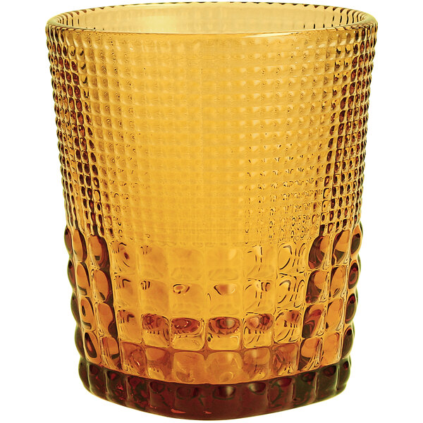 A close-up of a Fortessa Malcolm amber double old fashioned glass with a patterned design.
