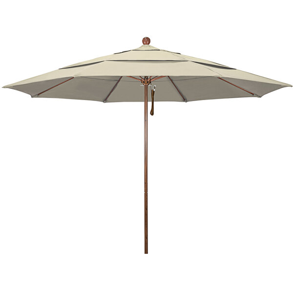 An antique beige California Umbrella with a wooden pole.