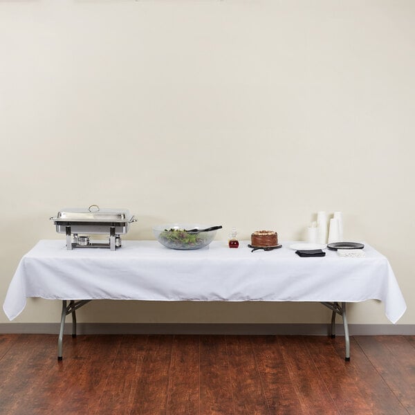 A white rectangular table with a bowl of food on it.
