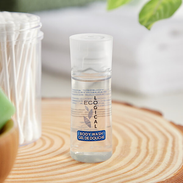 A clear bottle of EcoLOGICAL body wash gel on a wood surface.