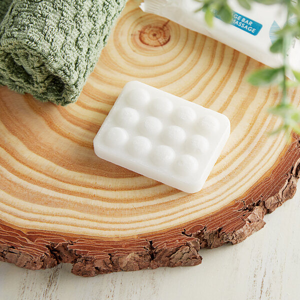 A white massage bar on a piece of wood with a towel.