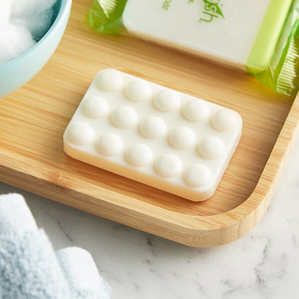 A tray with Nourish grapefruit body bar soap and a towel on a white countertop.