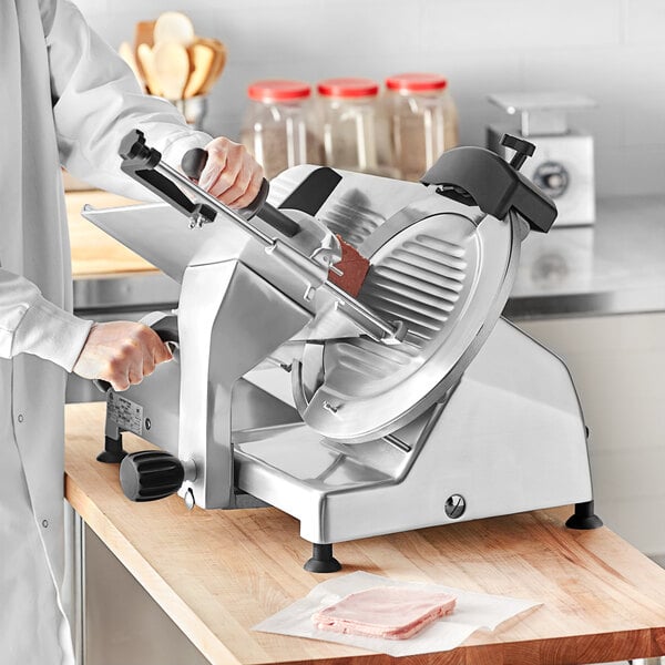 A person using a Centerline by Hobart meat slicer to cut meat.