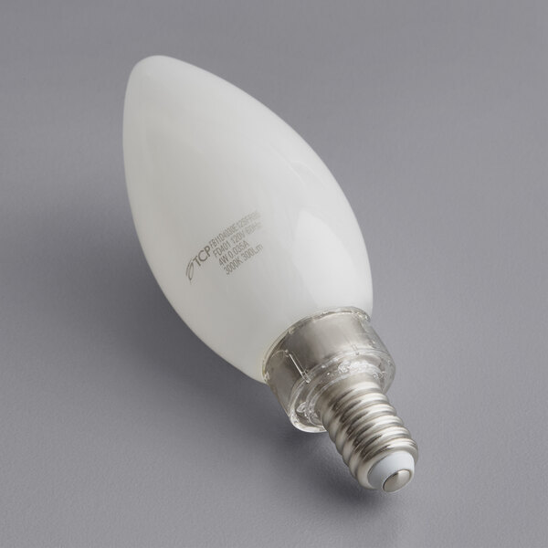 A TCP dimmable LED frosted filament light bulb with a silver E12 base on a gray surface.