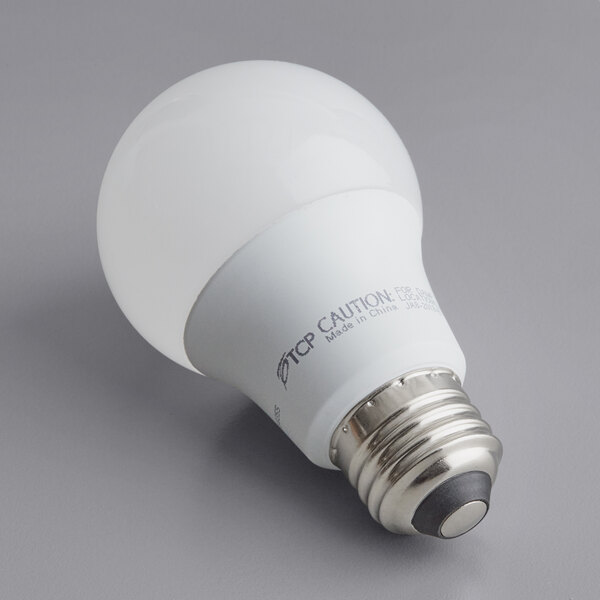 A TCP dimmable LED light bulb with a white label on a gray surface.