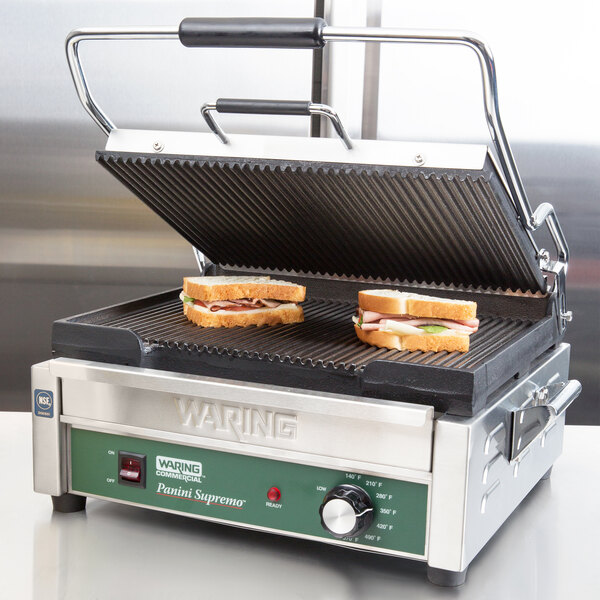 A Waring Panini Supremo grill with two sandwiches on it.