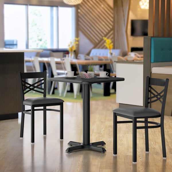 A Lancaster Table & Seating cherry and black laminated table top with a black table base set up in a restaurant dining area.