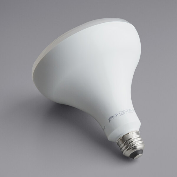 A close-up of a TCP Elite 15W Dimmable LED light bulb with white light.