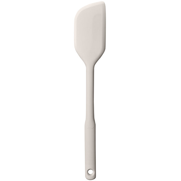 An OXO Good Grips beige silicone spatula with a white handle.