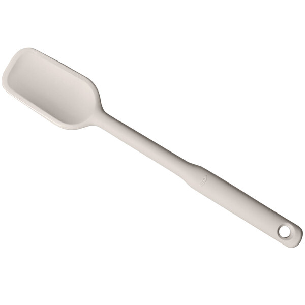 An OXO Good Grips white silicone spoonula with a hole in the handle.