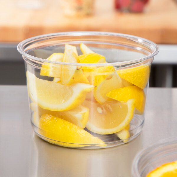 A Fabri-Kal clear plastic deli container with lemon slices inside.