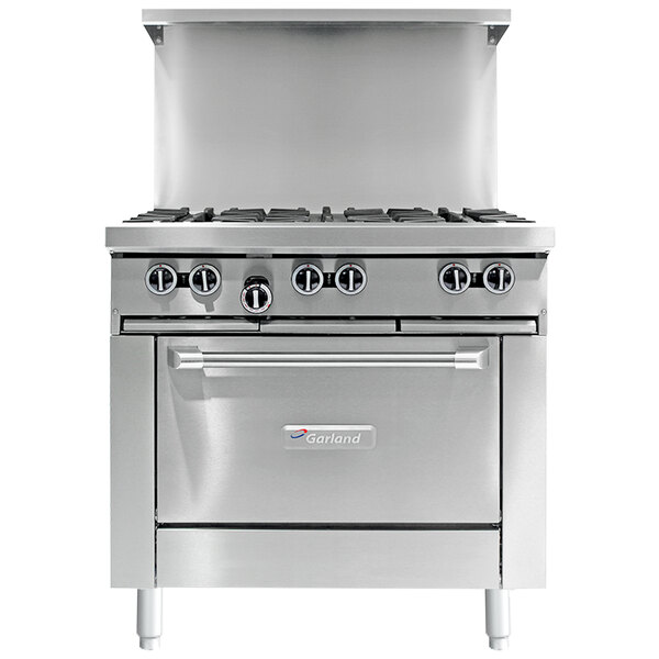 A stainless steel Garland commercial gas range with a griddle and oven door open.
