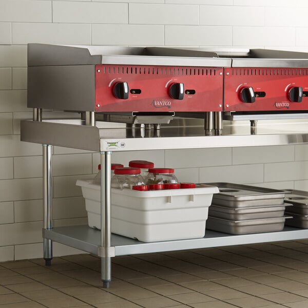 A Regency stainless steel equipment stand with a shelf holding metal containers.