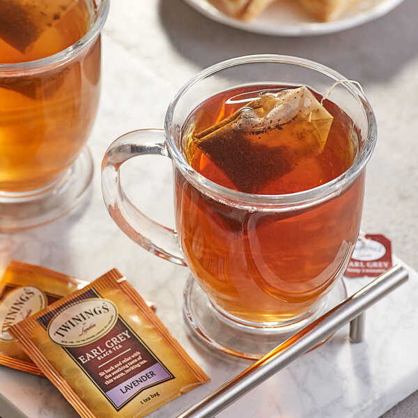 A glass mug of Twinings Earl Grey with Lavender Tea with a tea bag in it.