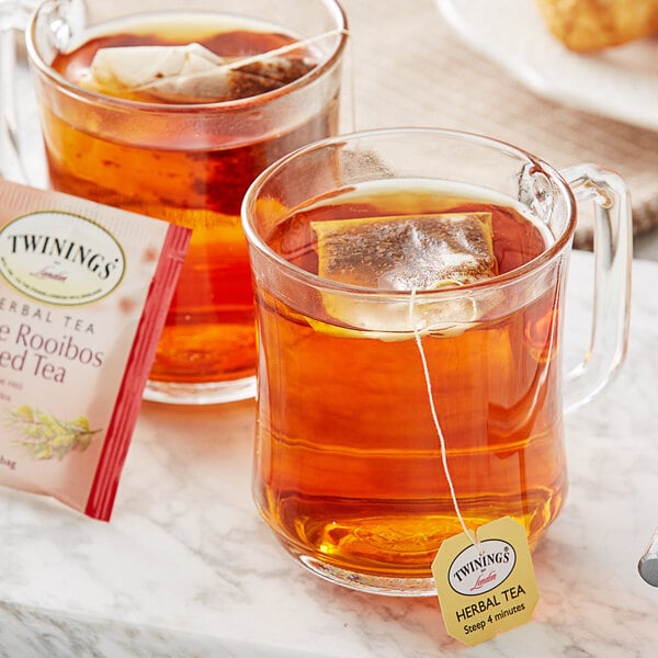 A glass mug of Twinings Pure Rooibos tea with a tea bag in it.