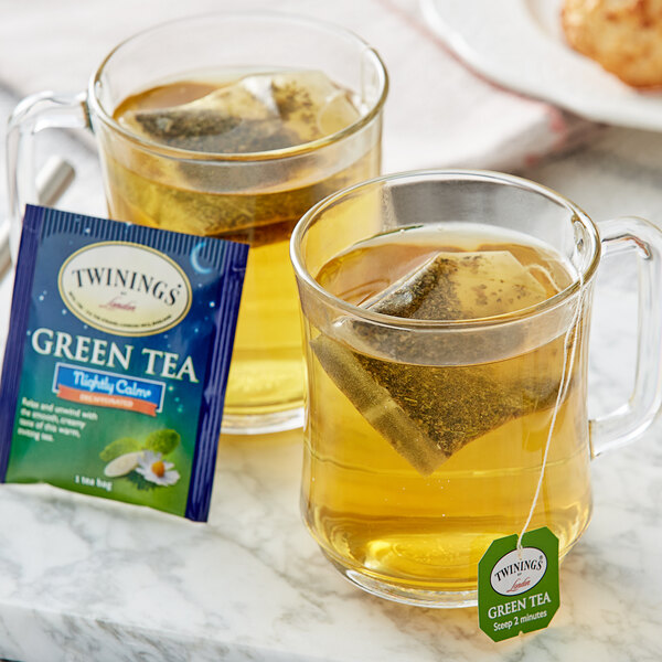 Two cups of Twinings Nightly Calm Green Decaffeinated tea with tea bags.