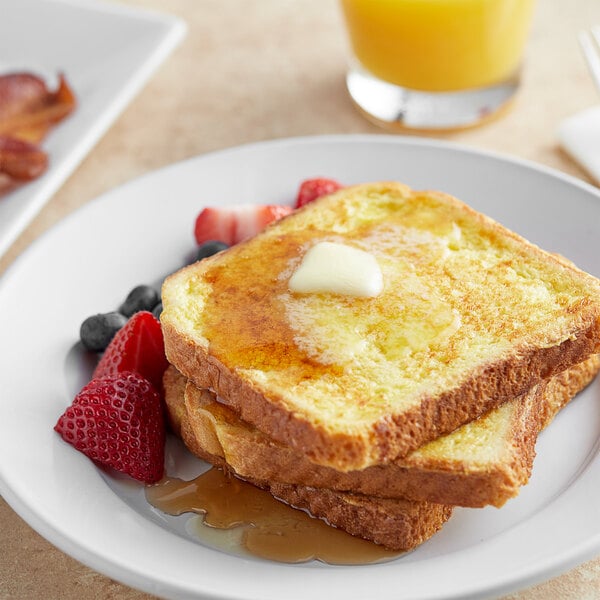 A plate of Papetti's plain French toast with syrup and fruit.