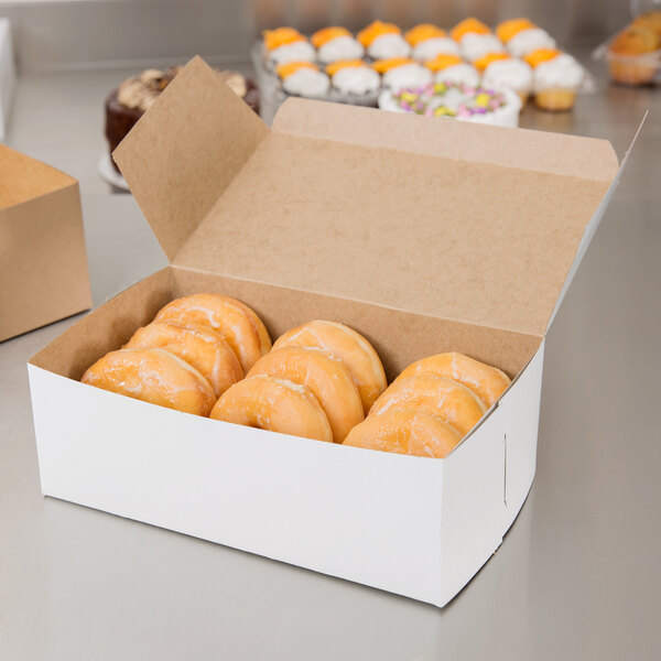 A white donut box on a counter.