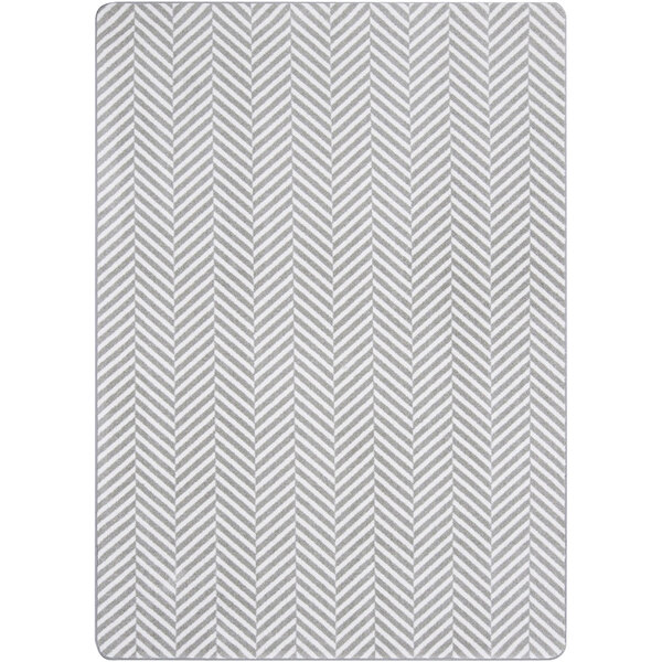 A Joy Carpets rectangle area rug with a gray and white chevron pattern and a white border.