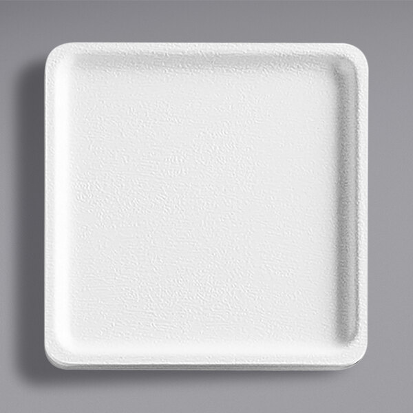 A white square plate with a textured surface.