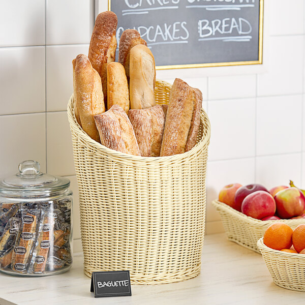 A woven rattan basket filled with bread and fruit on a bakery counter.