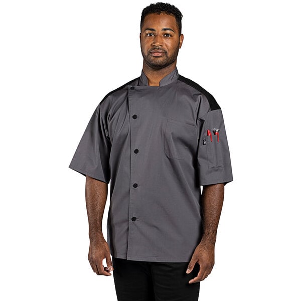 A man wearing a slate gray Uncommon Chef Rogue Pro Vent chef coat with mesh back.