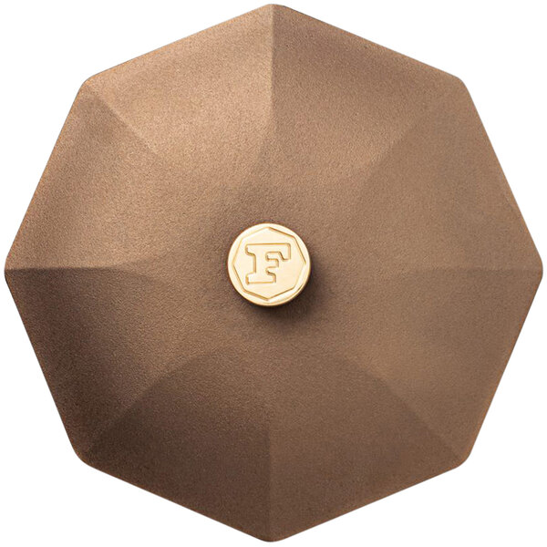 A brown octagonal FINEX cast iron cover with a gold logo.