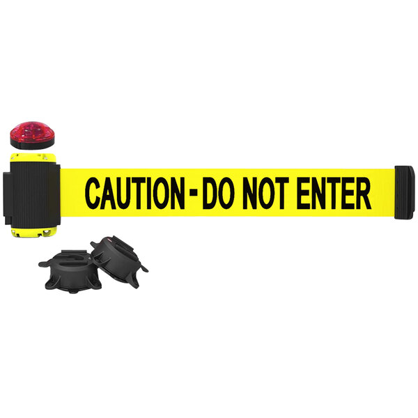A yellow Banner Stakes wall mount barrier with a "Caution - Do Not Enter" sign and two black magnetic objects.