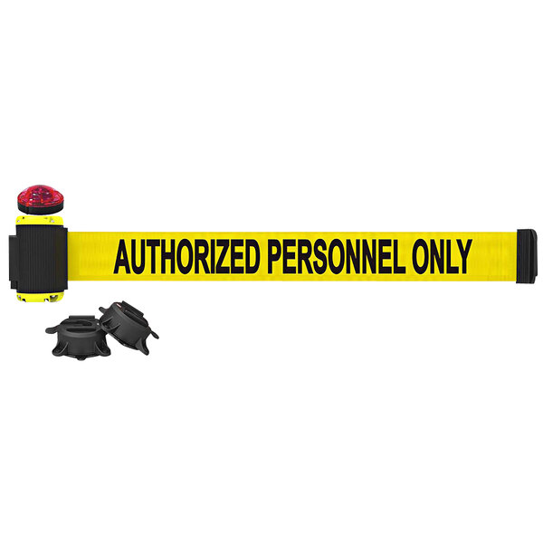 A yellow Banner Stakes wall mount barrier with black "Authorized Personnel Only" text.