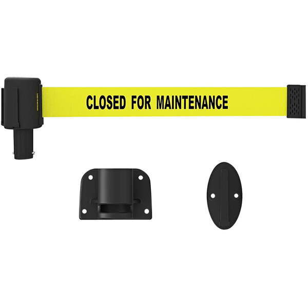 A yellow Banner Stakes wall mount system with black text reading "Closed for Maintenance" on a black oval object with two holes.