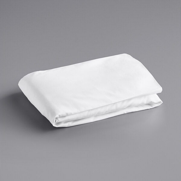 A folded white Oxford Super twin size fitted sheet on a gray surface.