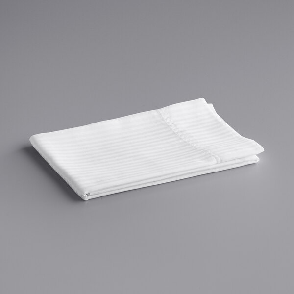 A folded white Oxford Super Blend pillow case on a gray surface.