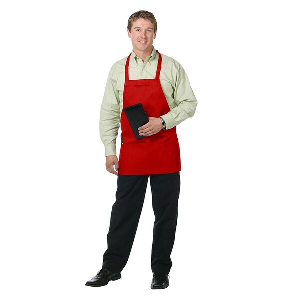A man in a Chef Revival red apron holding a tablet on a counter in a professional kitchen.