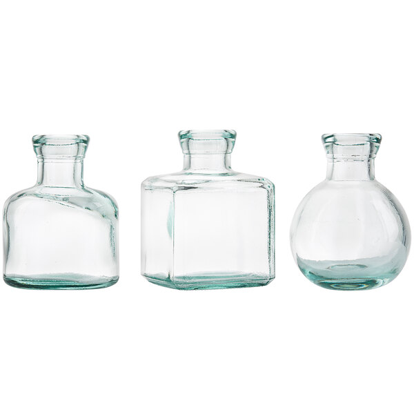 Three clear glass bottles with green caps.