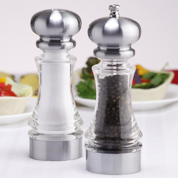 A Chef Specialties Lehigh salt and pepper shaker set on a table with white substance in the salt shaker.