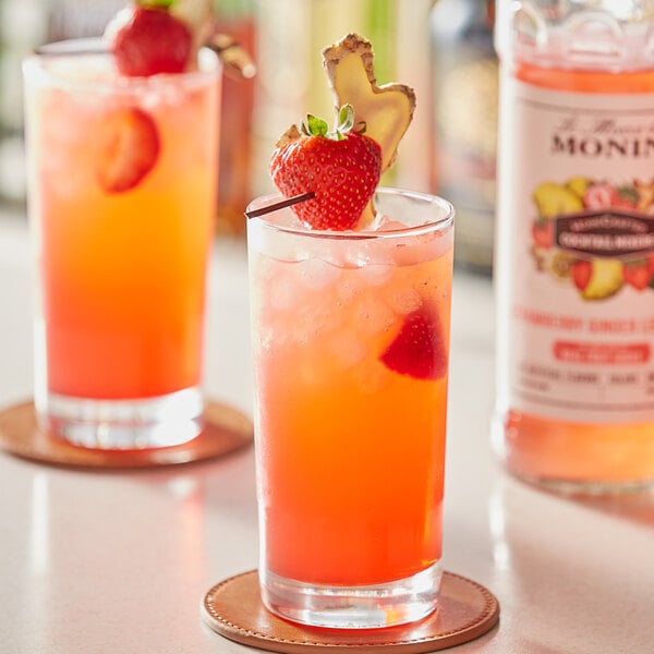 A close-up of two glasses of pink Monin Strawberry Ginger Lemonade.