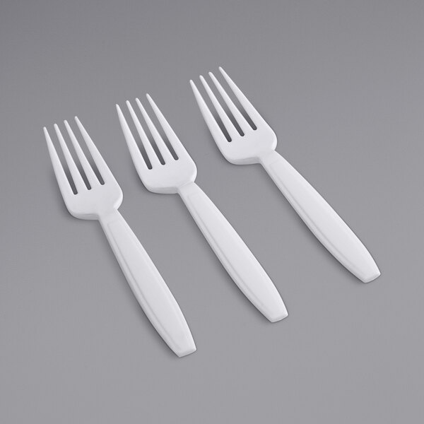 A close-up of three Fineline white plastic forks.