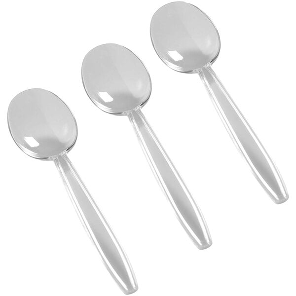 A close-up of a Fineline Flairware clear plastic soup spoon.