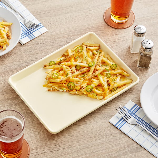 A Baker's Mark ivory non-stick sheet pan with french fries on it.