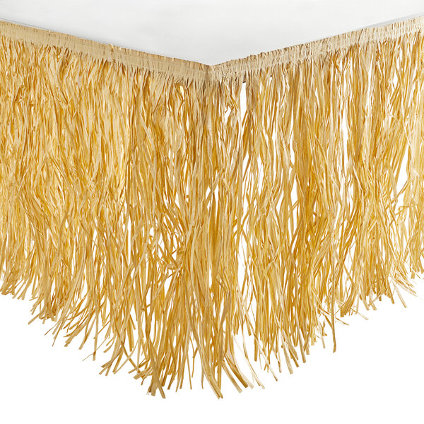 An Amscan natural grass table skirt with long fringes.