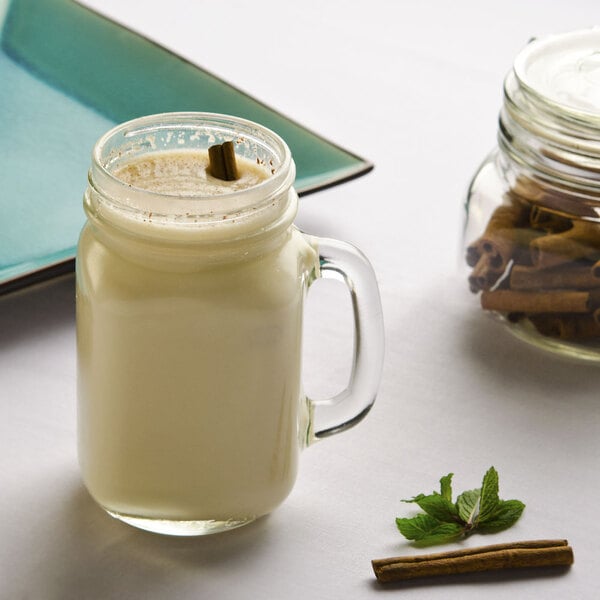 A Libbey mason jar filled with white liquid and a cinnamon stick.