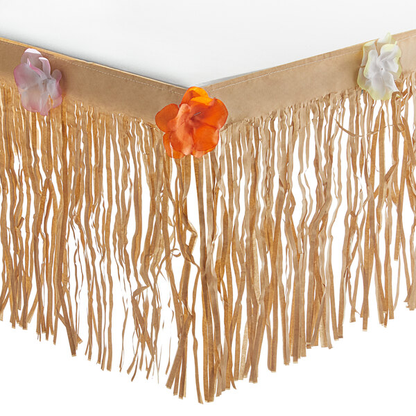 A brown fringed paper table skirt decorated with flowers and tassels.