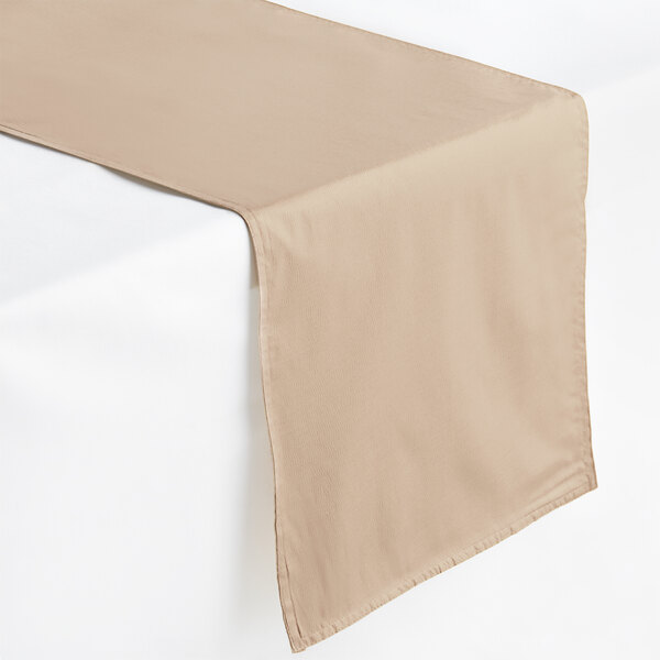 A rose gold rectangular cloth table runner on a white surface.