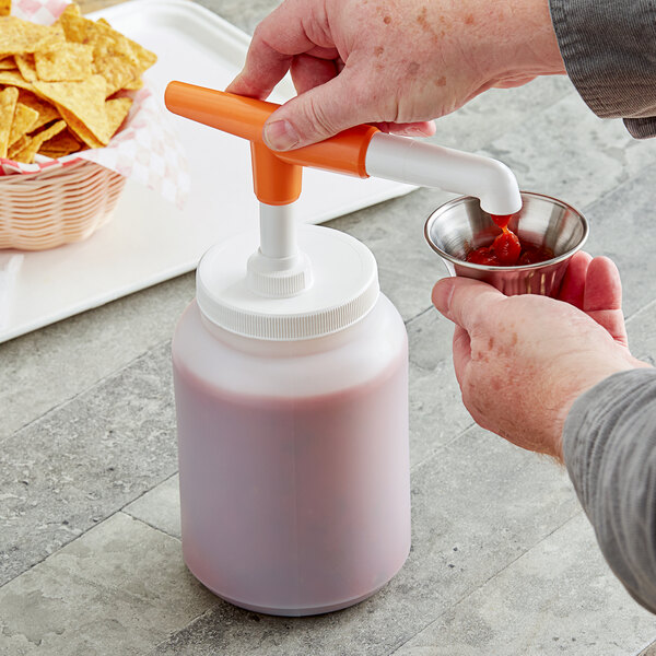 A person using a Choice condiment pump to pour ketchup into a bowl.