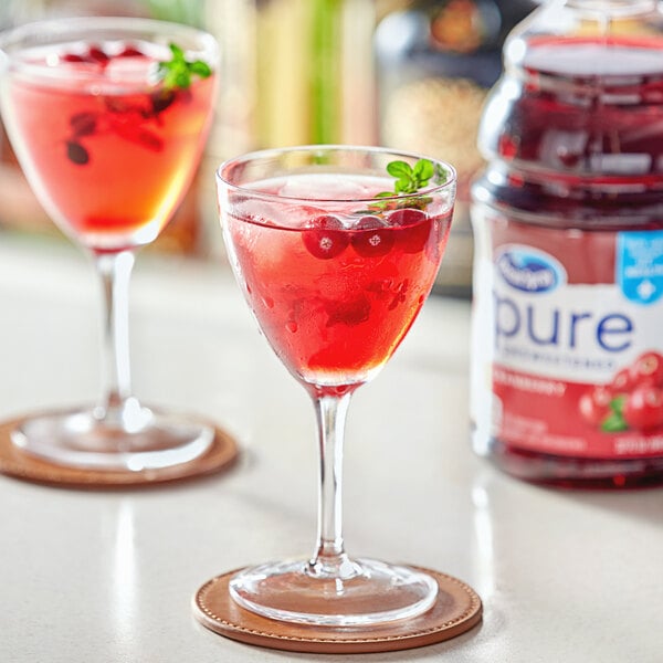 A glass of Ocean Spray Pure cranberry juice with berries in it.