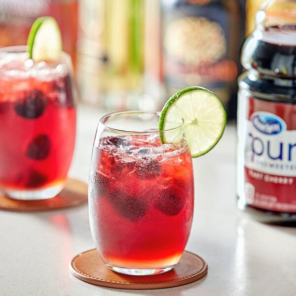 A glass of Ocean Spray Pure 100% Tart Cherry Juice with a lime wedge.